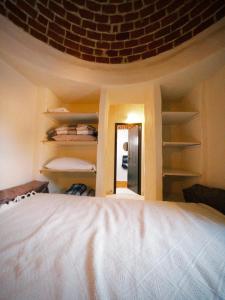 ein Schlafzimmer mit einem Bett und einer Ziegelwand in der Unterkunft Douira S+1 in Chebba