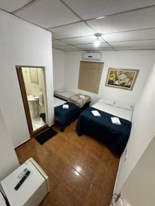 een kleine kamer met 2 bedden en een badkamer bij Casa de Temporada p 12 pessoas em Aparecida in Aparecida