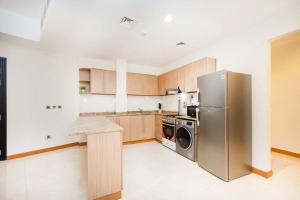 a large kitchen with a stainless steel refrigerator at Get Rooftop Pool at 2BR APT Near Mall Of Emirates 411 in Dubai