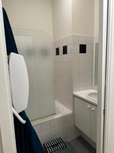 uma casa de banho branca com um lavatório e um WC em Apparemment cosy et chaleureux em Montauban