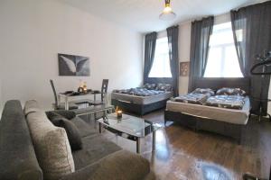 a living room with two beds and a couch at 23Sam Apartment vienna in Vienna