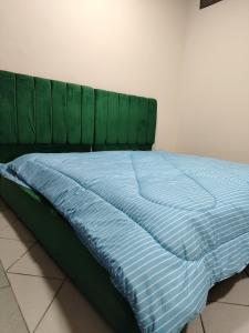 - un lit avec une tête de lit verte dans une chambre dans l'établissement شقق مفروشة Apartment 2 Bedroom Majaz3, à Charjah