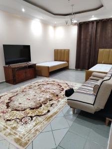 a living room with a tv and a rug at شقق مفروشة Apartment 2 Bedroom Majaz3 in Sharjah