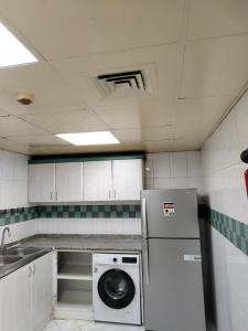 Il comprend une petite cuisine équipée d'un lave-vaisselle et d'un lave-linge. dans l'établissement شقق مفروشة Apartment 2 Bedroom Majaz3, à Charjah