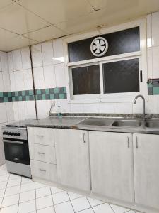 uma cozinha com um lavatório e uma janela em شقق مفروشة Apartment 2 Bedroom Majaz3 em Sharjah