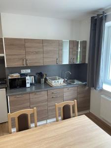 a kitchen with wooden cabinets and a table and chairs at TVM Ostrava 1 in Ostrava