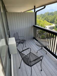 2 sillas y una mesa en el balcón en Cliff Dwellers Inn, en Blowing Rock