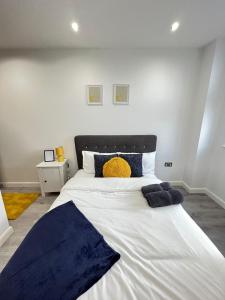 um quarto com uma grande cama branca com almofadas azuis em Leicester City Centre Flat em Leicester