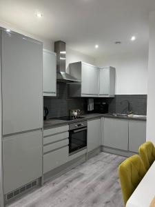 a kitchen with stainless steel appliances and white cabinets at Leicester City Centre Flat in Leicester