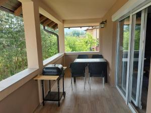 ein kleines Haus mit einem Balkon mit einem Tisch und Stühlen in der Unterkunft Apartman Feniks in Plijeskovo