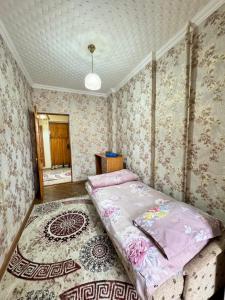 a bedroom with a bed in a room with wallpaper at 46 Самый центр Идеально для командированных и туристов Чисто оснащенно исправно уютно вместительно in Shymkent
