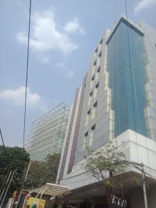 a tall glass building with a tree in front of it at Hotel Svm Pride Banjara-Hot Live Counter-Road View Stay- Free Lavish Buffet Breakfast-18 Percent Off In Restaurant Food Order in Hyderabad