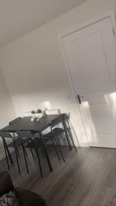 a black table and chairs in a room with a door at Cute house Littleover close to amenities hospital in Derby