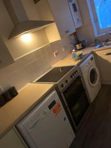 a kitchen with a stove top oven and a microwave at Cute 2 bedroom house Littleover close to amenities hospital in Derby