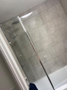 a shower with a glass door in a bathroom at Cute 2 bedroom house Littleover close to amenities hospital in Derby