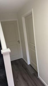 an empty room with a door and a wooden floor at Cute 2 bedroom house Littleover close to amenities hospital in Derby
