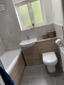 a bathroom with a sink and a toilet and a bath tub at Cute house Littleover close to amenities hospital in Derby