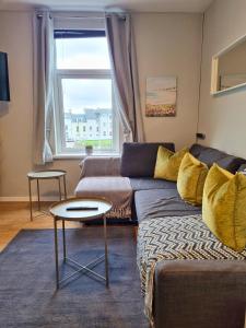 ein Wohnzimmer mit Sofa und Tisch in der Unterkunft Princess Green 5 - Portrush by the Sea in Portrush