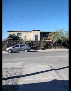 een auto geparkeerd op straat voor een huis bij Jardin Imperial in Mexicali