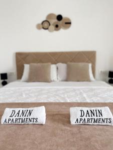 a bed with two admit participants signs on it at Danin apartmani in Bar