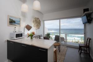 a kitchen and living room with a view of the ocean at Casa Da Praia in Porto Formoso