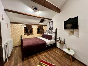 Schlafzimmer mit einem Bett und einem Flachbild-TV in der Unterkunft Hotel Fjorr in Prizren