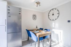 mesa de comedor con sillas azules y reloj en UHCW House Coventry en Coventry