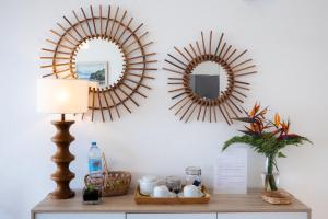 two mirrors on a wall above a table with a lamp at Casa Da Praia in Porto Formoso
