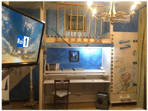 Zimmer mit einem Schreibtisch und einem TV in einem Zimmer in der Unterkunft La Finestra sul Fiume in Fossombrone