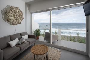 Porto FormosoにあるCasa Da Praiaのリビングルーム(ソファ付)が備わり、海の景色を望めます。