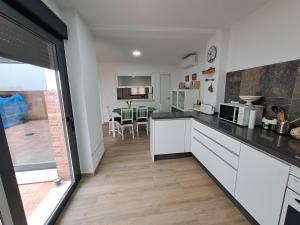 cocina con armarios blancos y comedor en CASA CATALINA en Priego de Córdoba