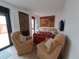 sala de estar con 2 sillas y chimenea en CASA CATALINA en Priego de Córdoba