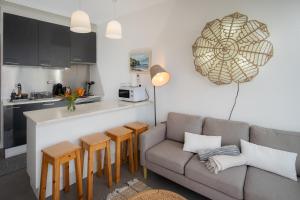 a living room with a couch and a kitchen at Casa Da Praia in Porto Formoso