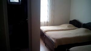 two beds in a room with a window at Guest House Batumi in Batumi