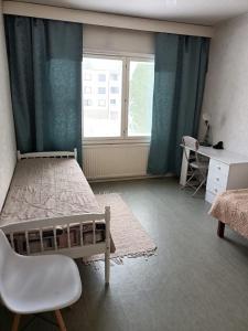 a bedroom with a bed and a desk and a window at Kolmio Väinöläntie 6 in Lieksa