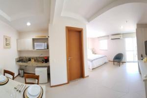 ein Zimmer mit einer Küche und ein Schlafzimmer mit einem Bett in der Unterkunft Porto Marina Itacuruça Mangaratiba in Mangaratiba