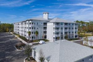 - un grand immeuble blanc avec un parking dans l'établissement Riverfront Living Near Jacksonville International Airport, à Jacksonville