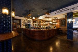 a bar in a restaurant with a large wooden counter at Abel Heywood Boutique Hotel in Manchester