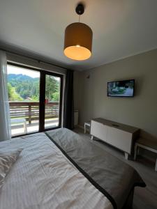 a bedroom with a large bed and a large window at Apartamente de inchiriat- Garden Apart Predeal in Predeal