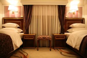 a hotel room with two beds and a stool at Hotel Villa Viktorija in Banja Luka