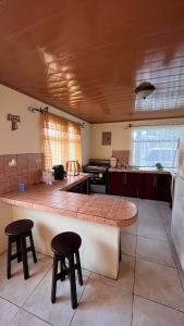 een keuken met een tafel en twee krukken. bij Casa morfo in Bijagua
