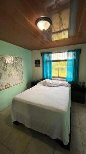 a bedroom with a large bed with blue curtains at Casa morfo in Bijagua