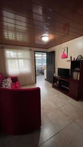 uma sala de estar com um sofá e uma televisão em Casa morfo em Bijagua