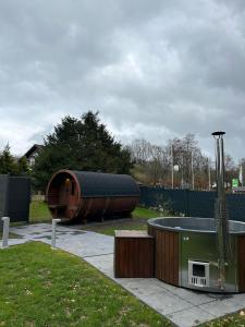 um quintal com uma banheira de hidromassagem e um edifício de madeira em Traumfabrik Eifel mit Sauna & Whirlpool em Monschau