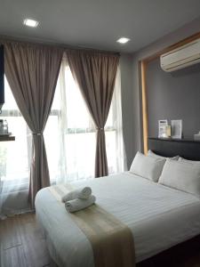 a bedroom with a large bed with a large window at Sunset Villa Inn in Pantai Cenang