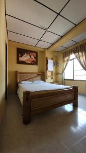 a bedroom with a large bed and a large window at Hotel Mansur in La Tebaida
