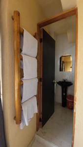 baño con una pila de toallas colgadas en la pared en Hotel Mansur, en La Tebaida