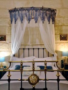 a bedroom with a bed with a canopy at Myrtle Suite - Valletta ground floor apartment in Valletta