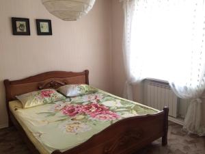 トリヤッチにあるApartment Na Gidrostroyevskoyのベッドルーム1室(花の飾られたベッド1台付)