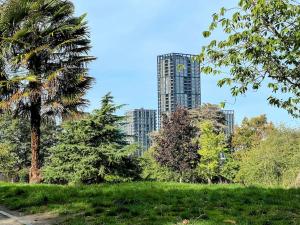 a tall building in the background of a park with trees at Short term apartment in London in London